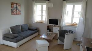 a living room with a couch and a chair at Ferienwohnungen Mühlenhof Oberseifersdorf in Mittelherwigsdorf