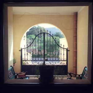 uma janela arqueada com um portão de ferro com vista em Masri Accommodation em Il-Pergla