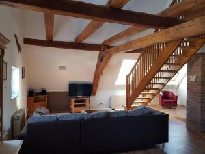 a living room with a blue couch and a staircase at Ferienwohnung "Zum Hexenhäusle" in Weißenburg in Bayern