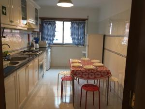 a small kitchen with a table and chairs in it at Apartamento Familiar Lisboa Taguspark in São Marcos