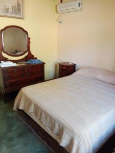 um quarto com uma cama, uma cómoda e um espelho em Parador La Rosita em San Agustín de Valle Fértil