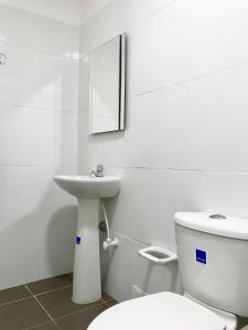 ein weißes Bad mit einem WC und einem Waschbecken in der Unterkunft CARIBE 102 - 1 in San Andrés