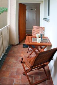 a wooden table and chairs on a patio at Wohnen am Roseneck in Berlin