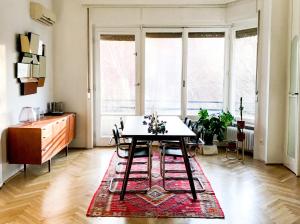 a dining room with a table and chairs on a rug at Spacious Bauhaus icon flat with fitness room in Central Buda, close to the river and Margaret island in Budapest