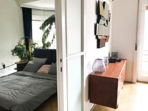 a bedroom with a bed and a table with a lamp at Spacious Bauhaus icon flat with fitness room in Central Buda, close to the river and Margaret island in Budapest