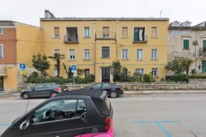 un'auto parcheggiata in un parcheggio di fronte a un edificio di Apartment Nicol a Pola (Pula)