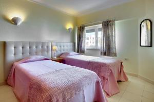 een slaapkamer met twee bedden en een raam bij Apartamentos do Atlantico in Albufeira +21 foto's