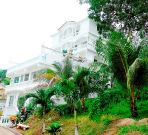 um grande edifício branco com palmeiras em frente em Taboga Palace SPA Hotel em Taboga