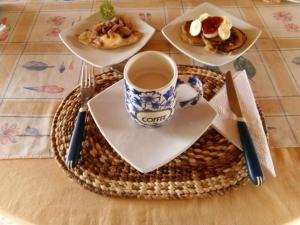 a table with plates of food and a cup of coffee at Buganvilla Guest House in Ballenita