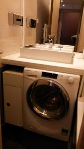 a washing machine in a bathroom with a sink at Aparthotel Paris 15 Porte de Versailles in Issy-les-Moulineaux