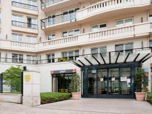 un bâtiment avec une entrée en noir et blanc pour un bâtiment dans l'établissement Aparthotel Paris 15 Porte de Versailles, à Issy-les-Moulineaux