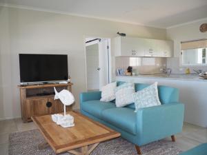 a living room with a blue couch and a table at Solace in South Mission Beach