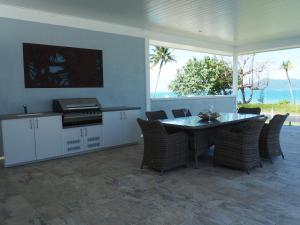 cocina y comedor con mesa y sillas en Solace en South Mission Beach