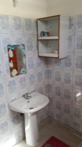 y baño con lavabo blanco y espejo. en Les petits sykriyés, en Sainte-Anne