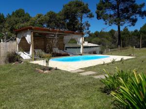 una piscina en un patio con un pabellón en La Romeria, en Punta del Este