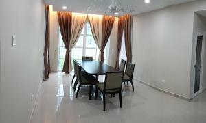 una sala da pranzo con tavolo e sedie neri di D'Bangi Villa a Kampong Sungai Ramal Dalam