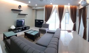 een woonkamer met een bank en een tv bij D'Bangi Villa in Kampong Sungai Ramal Dalam