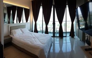a bedroom with a bed and large windows at EVO SOHO STUDIO Suites in Kampong Sungai Ramal Dalam +7 photos