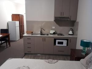 a kitchen with a sink and a microwave at Moe Motor Inn - Contactless 24 hour Checkinn Available in Moe