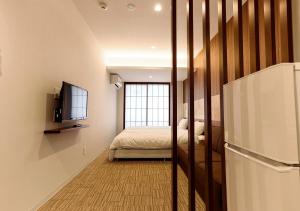 1 dormitorio con 1 cama y TV en una habitación en Irori Kyoto Station Higashi-Honganji, en Kioto