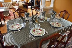 a table with plates and glasses on top of it at Apple Tree Historic B&B in Niagara-on-the-Lake