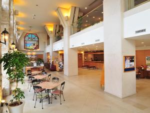 a cafeteria with tables and chairs in a building at Hotel Sunroute Sopra Kobe in Kobe