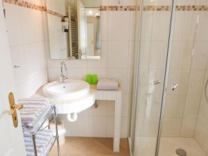 un baño con lavabo y ducha en Bungalow *Ual Welhüs*, en Norddorf 9 fotos más