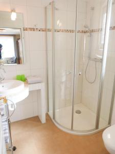 un baño con ducha y lavabo en Bungalow *Ual Welhüs*, en Norddorf