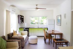 Villa Marine Holiday Apartments Cairns في Yorkeys Knob: غرفة معيشة مع أريكة وطاولة