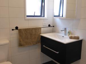 a bathroom with a sink and a toilet at Bungalow on Bell Common in Tauranga