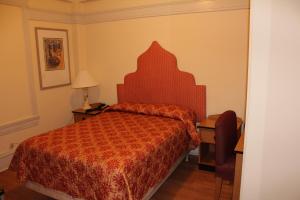 a bedroom with a bed with a red comforter at Layne Hotel in San Francisco