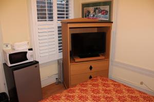a bedroom with a tv on a dresser with a microwave at Layne Hotel in San Francisco