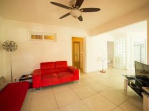 a red couch in a living room with a ceiling fan at Bounaco in Le Gosier