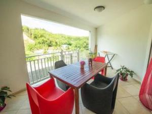 a dining room with a table and red chairs at Bounaco in Le Gosier