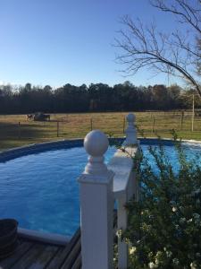 a swimming pool with a white fence and a field at Dublin Farm in Dublin