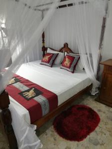 - une chambre avec un lit à baldaquin dans l'établissement Sumimal Resort Polhena, à Matara