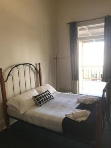 
a bed that is in a room with a window at Grosvenor Hotel in Victor Harbor
