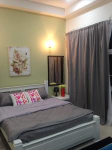 a bedroom with a large bed with pink pillows at Julia's Cottage in Kota Bharu