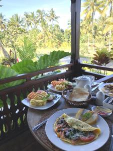 a table with plates of food on a balcony at Villa Neyang in Ubud +156 photos