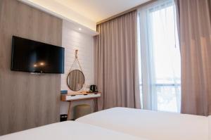 a hotel room with a bed and a flat screen tv at Ana Hotel Jakarta in Jakarta