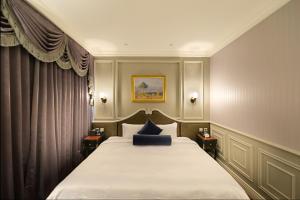 Tempat tidur dalam kamar di Golden Tulip RS Boutique Hotel-Tainan