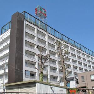 un gran edificio con un árbol delante en Hotel Housen Soka, en Soka