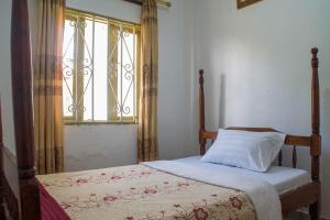 Cama en habitación con ventana y cama sidx sidx sidx sidx en Efraz Motel Kanungu, en Kinkizi