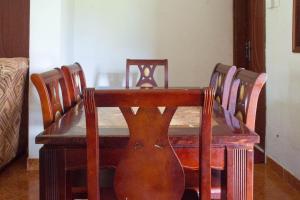 a dining room table and chairs with a guitar on it at Efraz Motel Kanungu in Kinkizi