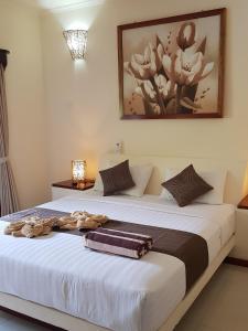 a bedroom with a large bed with towels on it at Senang Villa by Ambassador in Gili Islands