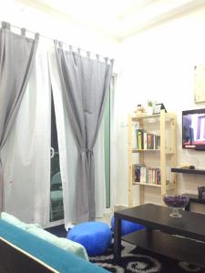 a living room with a blue couch and a table at Julia's Cottage in Kota Bharu