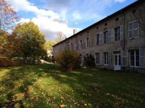 Lodge Hôtel de Sommedieue Verdun في Sommedieue: مبنى قديم وامامه ساحة عشب