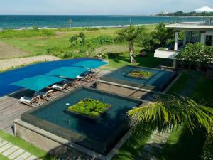 an overhead view of a swimming pool with two umbrellas at Sanur Residence in Sanur
