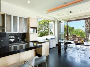 a kitchen with black counter tops and a large window at Sanur Residence in Sanur