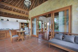 ein Wohnzimmer mit einem Sofa und einem Tisch in der Unterkunft Graha Sandat Villas by Pramana Villas in Ubud